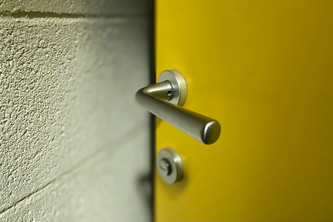 Stainless steel door lever on a wooden door